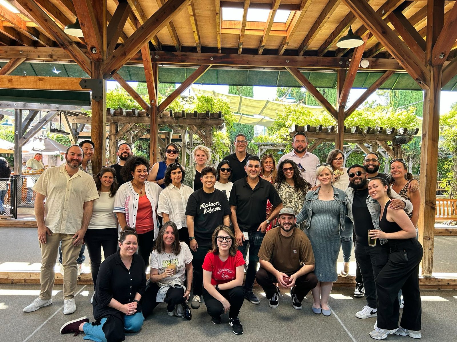 Diana with her team in a large group photo under a wooden pavilion